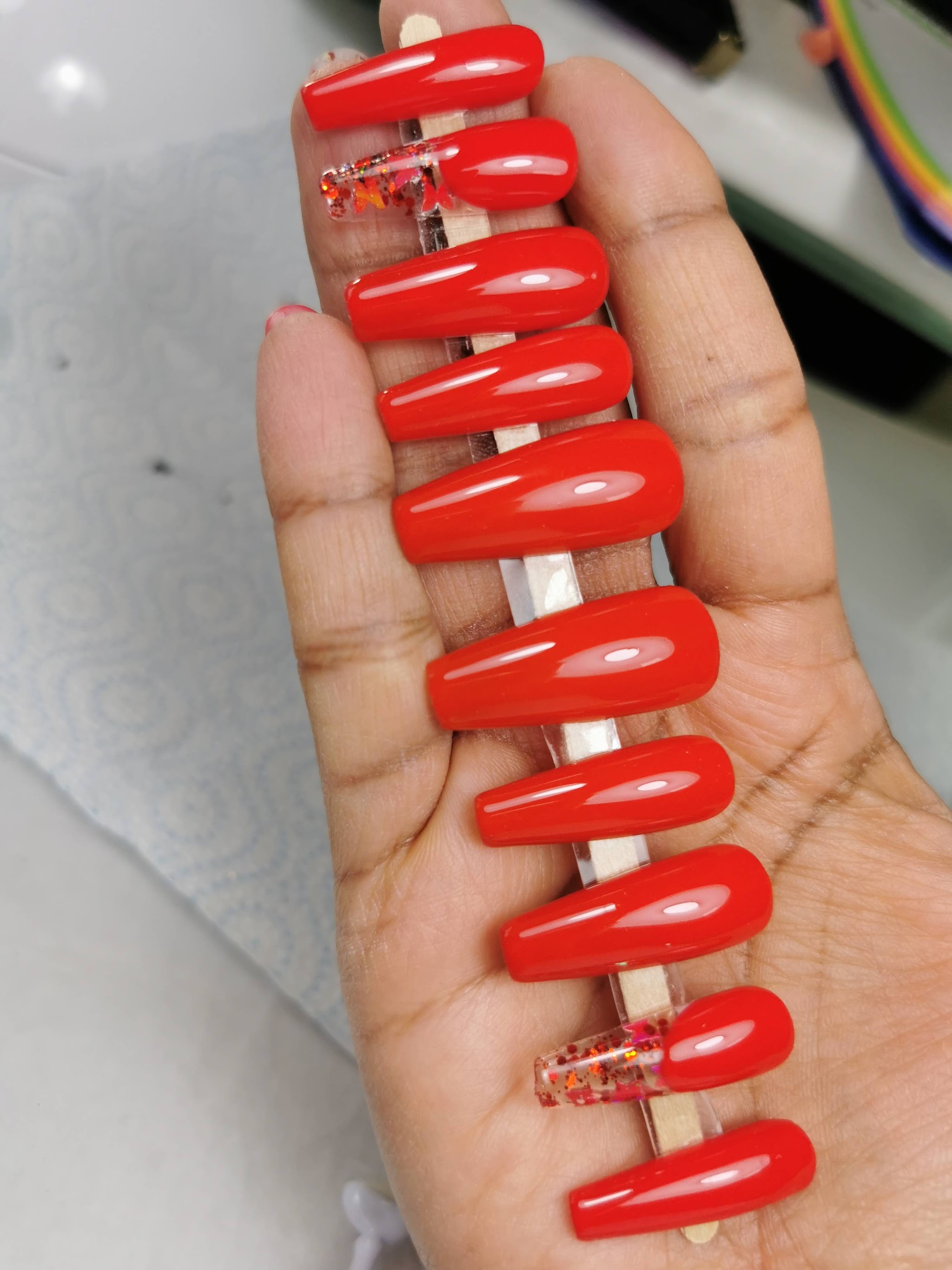 Rode kleurstalen met verschillende nagelafwerkingen